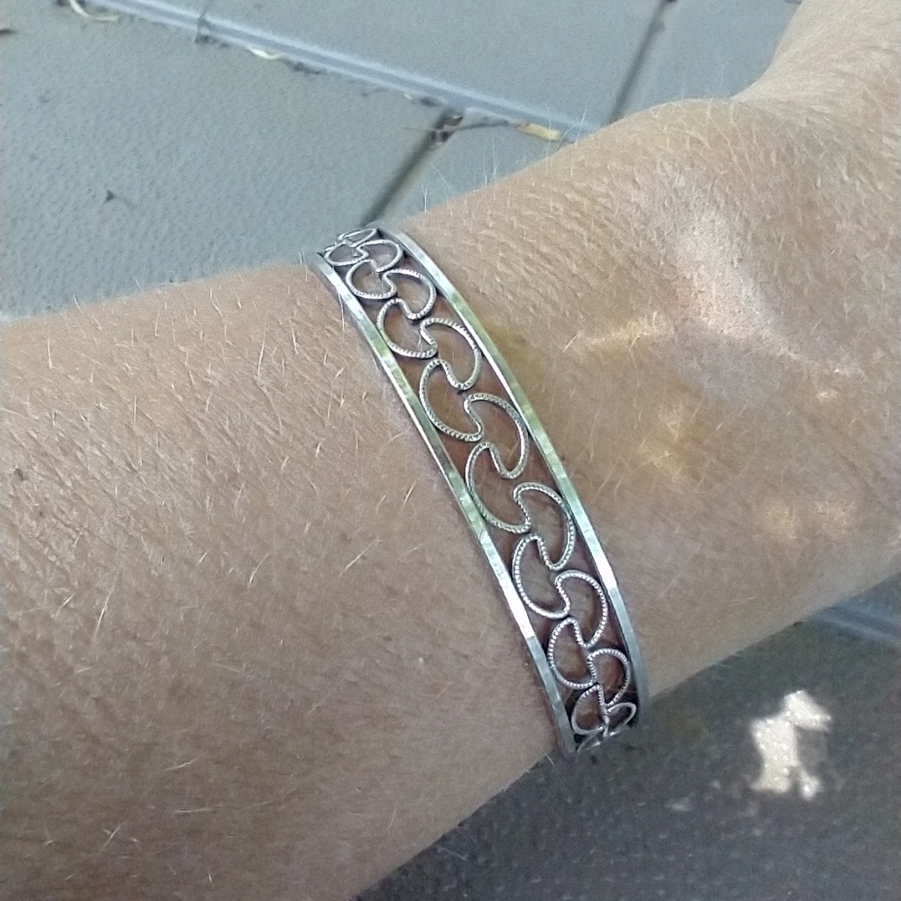 Women's silver tone scroll bracelet. Adjustable.